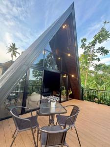 a patio with a table and chairs on a deck at Romantic A-Frame Cabin w/ a View + WiFi in Samal