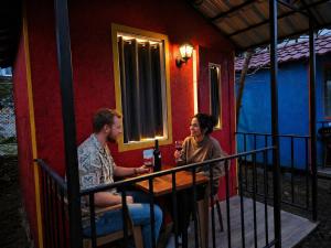 a man and woman sitting at a table outside of a house at The Friends Hostel & Sauna in Kutaisi