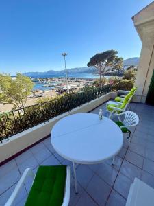 a white table and chairs on a balcony with a view of the beach at Liberty Seaview Apartment Cala Gonone in Cala Gonone