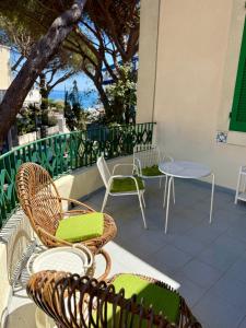 a group of chairs and tables on a balcony at Liberty Seaview Apartment Cala Gonone in Cala Gonone