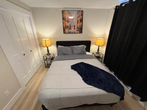 a bedroom with a large bed with two lamps at Modern Private Suite in Moncton