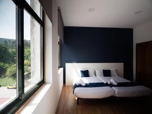 a bedroom with a bed and a large window at Bahía de San Simón in Redondela