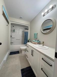 a bathroom with a sink and a toilet and a mirror at Modern Private Suite in Moncton