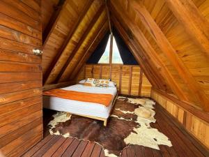 a bedroom with a bed in a wooden cabin at Refugio Nidos del Condor Cocora in Salento