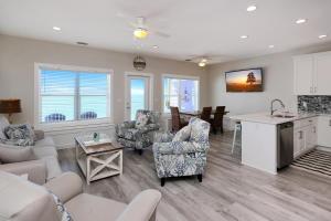 a living room with white furniture and a kitchen at Beach Fantasies A by Pristine Properties Vacation Rentals in Mexico Beach