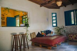 a living room with a couch and two bar stools at Hogar na mata in Ubatuba