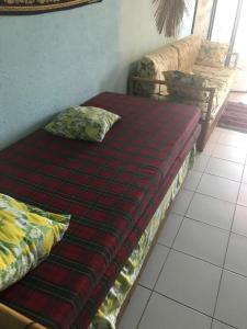 a bed with a red comforter and pillows on a floor at casa del pescatore in San-Nicolao +25 photos