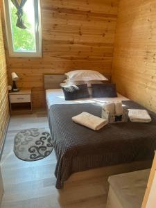 a bedroom with two beds in a log cabin at COMPLEX TURISTIC Gradina de corzi si Aventura Eselnita in Eşelniţa