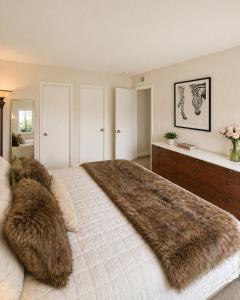 a bedroom with a large bed with a fur blanket at Beach Condo in Dana Point +12 photos