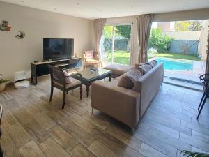 a living room with a couch and a table and a tv at Casa chacras in Chacras de Coria