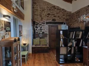 a room with a stone wall and a book shelf at Casa Fabiana in Montenegro de Cameros