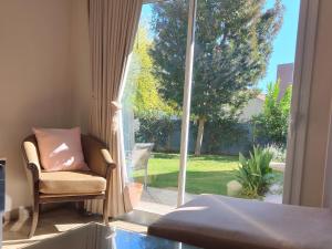 a bedroom with a chair and a large window at Casa chacras in Chacras de Coria