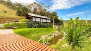 a house on a hill with a pond in front of it at Luxury Chalet Retreat with Jacuzzi & Fireplace in Itajaí
