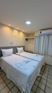 a bedroom with a large bed with white sheets at Hotel Pousada Arco Íris Manaira in João Pessoa +41 photos