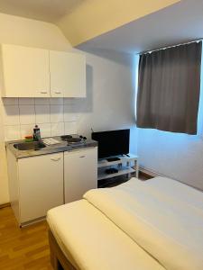 a small room with a bed and a kitchen at Hotel Westend in Cologne