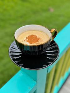 a cup of coffee sitting on a plate on a table at Refugio Nidos del Condor Cocora in Salento +28 photos