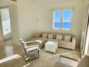 a living room with a couch and a chair at Mare e Relax - La Villetta ai Tre Ponti - Trilocale in Sanremo +48 photos