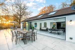 a house with a patio with a table and chairs at Luxury Ascot Villa Steps from Royal Ascot, 5 mins to Legoland Windsor Resort, 10 mins to Windsor Castle in Ascot