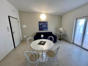 a living room with a table and chairs and a couch at Fortezza Apartments in Le Castella