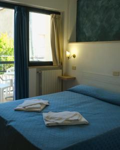 a bedroom with a blue bed with two towels on it at Hotel Timiama in Peschici +32 photos