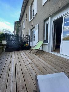 a wooden deck with a bench on a house at Studio charmant avec terrasse privée in Oradour-sur-Glane