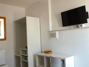 a room with a desk and a tv on a wall at Hotel Timiama in Peschici