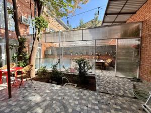 a patio with a table and chairs in a building at Duplex80A in Tashkent