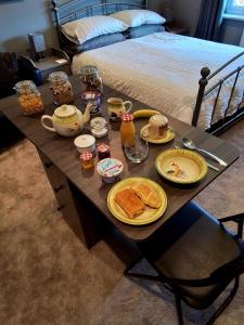 a table with plates of food on it with a bed at Large double room with spacious ensuite in Southbourne +13 photos