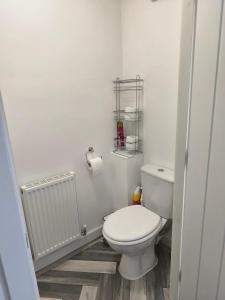 a white bathroom with a toilet and a radiator at Teddy's in Immingham +17 photos