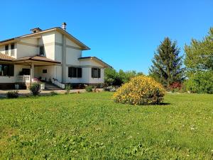 a house with a green lawn in front of it at Casa Yoga 2 Rilassati in una oasi di pace immersa nella natura a soli 60 minuti da Roma in Bassano Romano