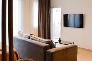 a living room with a couch and a tv at Shkoder City Center Rooms & Apartments in Shkodër
