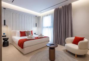 a bedroom with a bed and a chair at Space Row Exclusive Residences in Heraklio