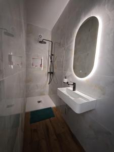 a white bathroom with a sink and a mirror at 119 Bliss Apartment in Sliema