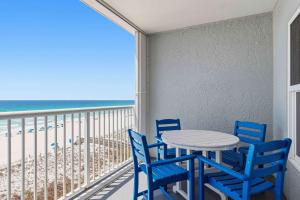a table and chairs on a balcony with the beach at Spacious gulf front condo with beach access in Fort Walton Beach