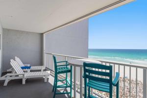 a balcony with chairs and a table and the ocean at Spacious gulf front condo with beach access in Fort Walton Beach