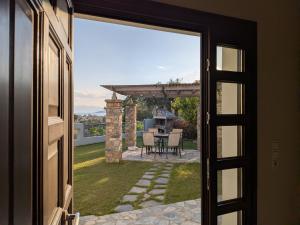 an open door to a patio with a table and a pergola at Homezie AGRIA in Agria
