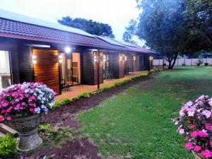 a building with a yard with flowers in front of it at Mountain Manor in Louis Trichardt