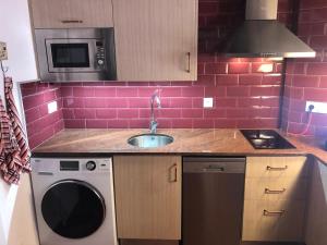 a kitchen with a sink and pink tiles on the wall at Dúplex con encanto EL PATI in Tarragona