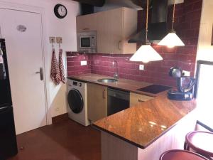 a kitchen with a counter and a sink and a dishwasher at Dúplex con encanto EL PATI in Tarragona +18 photos