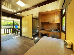 a kitchen with a table and a dining room with a deck at Camping El Roble in Valderrobres