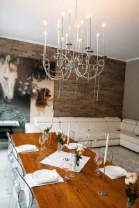 a dining room with a table and a chandelier at Маєток Ліс і Гори in Bukovel