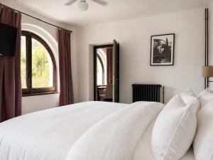 a white bed with white pillows in a bedroom at Angelats Hotel - A Signature Boutique Hotel & Restaurant in Ribes de Freser