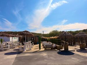 a group of chairs and tables and umbrellas at Camping de la Mer in Camiers