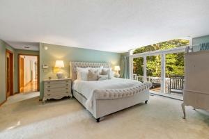 a bedroom with a large bed and a balcony at Bufflehead Hideaway in Kennebunk