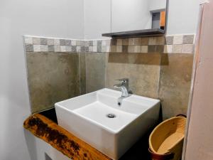 a bathroom with a white sink and a mirror at Mountain Manor in Louis Trichardt +9 photos