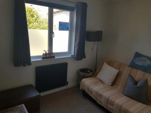 a living room with a couch and a window at Beechcroft 2 bed part house in Callington
