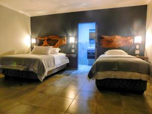 a bedroom with two beds and a walk in shower at Mountain Manor in Louis Trichardt