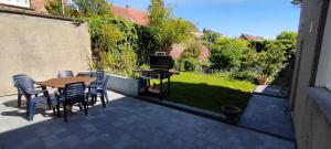 a patio with a table and chairs and a television at Wervik-94 in Wervik