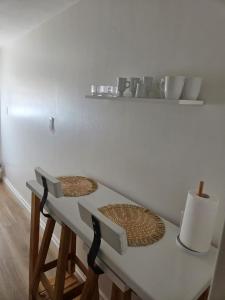 a kitchen counter with two stools and a white table at Olivos Calm Stay in Olivos