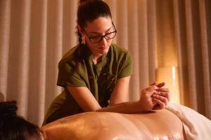 a woman sitting on a bed looking at her hands at Van Der Valk Luxembourg Arlon in Arlon